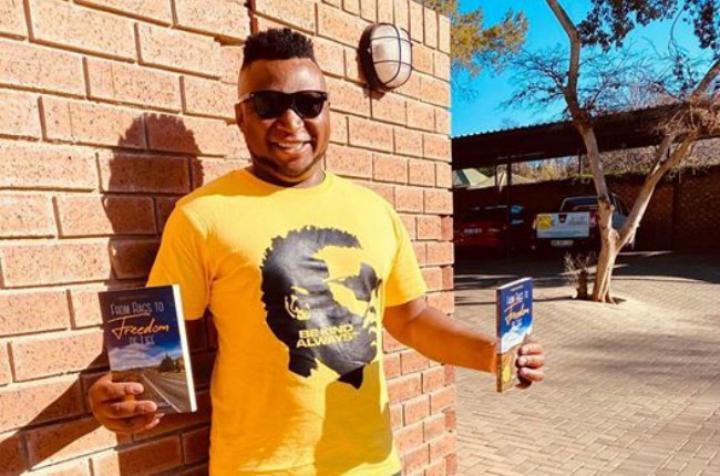 Siya Ngcangca holding copies of From Rags to Freedom of Life